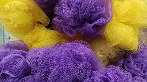 Close-up of colorful mesh bath sponges and loofahs in purple and yellow 動画素材 344041317