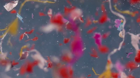 Close-up of colorful microplastic fragments floating in water, captured in .. Video stock 292564292