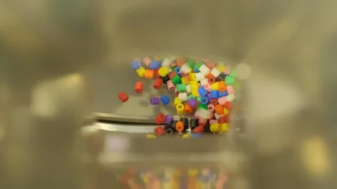 Close-up of colorful plastic pellets mixing inside industrial equipment Stock Footage 342604909
