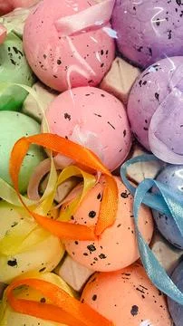 Close-up of colorful speckled Easter eggs with satin ribbons, vibrant festi.. Foto stock