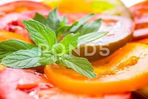 Close Up Of Colorful Tomato Slices With Green Twig Mint, Fresh Organic Food
