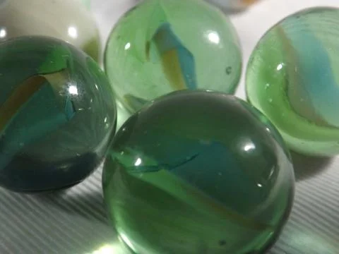 Close up of coloured marbles on a plain background Stock Photos