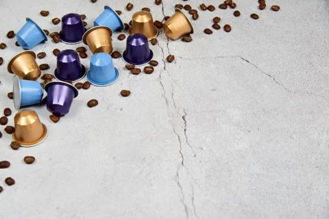 Close up colourful coffee capsules with roasted grains on gray concrete Stock Photos