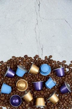 Close up colourful coffee capsules with some roasted grains on gray concrete Stock Photos