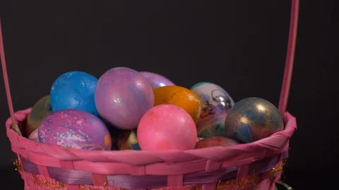 Close Up of Colourful Rotating Basket With Easter Eggs on Black Background 스톡 동영상 129057097