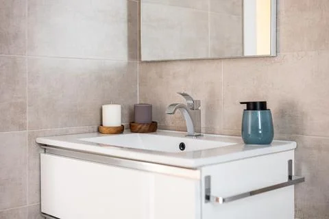 Close-up of comfortable large sink with a mirror in toilet with beige tiles, a Photos