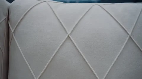 Close-up of a comfortable white sofa with diamond shapes. 4k video Stock Footage 231508172