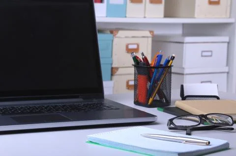 Close-up of comfortable working place in office with laptop, mouse, notebook Stock Photos