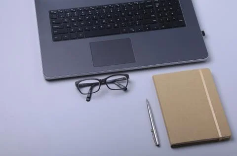 Close-up of comfortable working place in office with laptop, notebook, glasses Stock Photos
