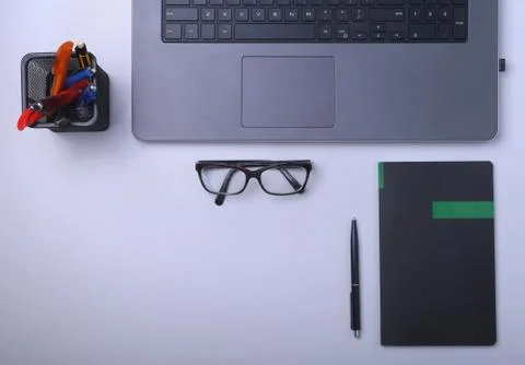 Close-up of comfortable working place in office with laptop, notebook, glasses Stock Photos