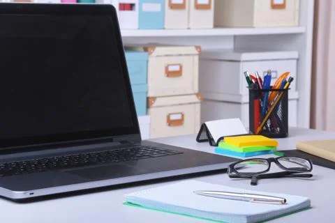 Close-up of comfortable working place in office with laptop, mouse, notebook Stock Photos