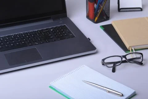 Close-up of comfortable working place in office with laptop, mouse, notebook Stock Photos