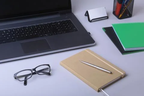 Close-up of comfortable working place in office with laptop, notebook, glasses Stock Photos
