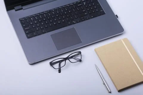 Close-up of comfortable working place in office with laptop, notebook, glasses Stock Photos