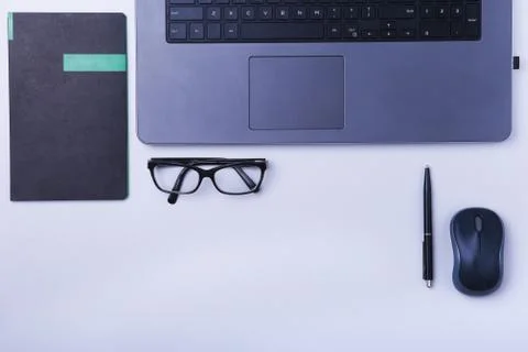Close-up of comfortable working place in office with laptop, mouse, notebook Stock Photos