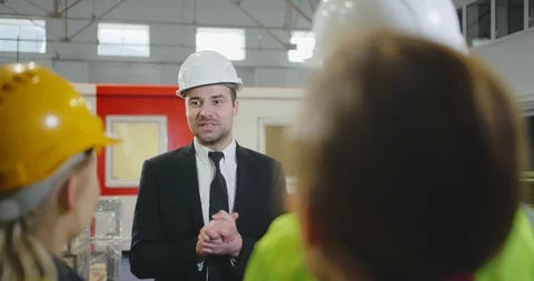 Close up of company manager talking with group of industrial workers while Stock Footage 112056252