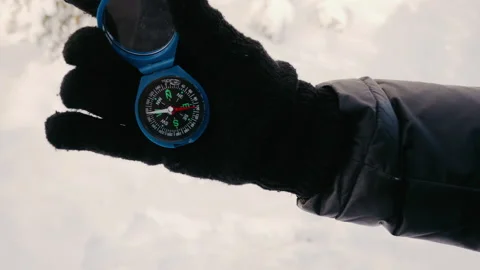 Close up on compass instrument in gloved hand. Media. Winter mountain trip Stock-Footage 226982112
