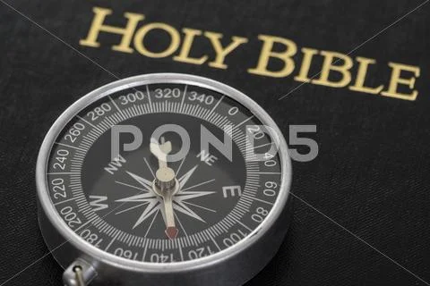 Close-up Of Compass Lying On Holy Bible Stock Photos