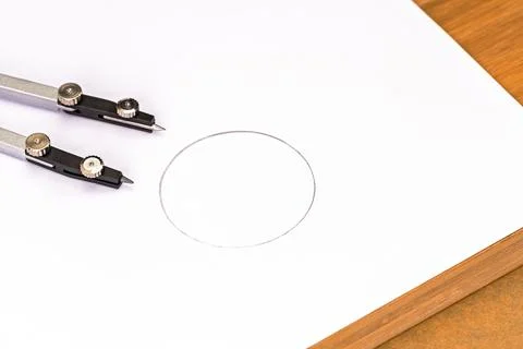 A close-up of a compass meticulously drawing a perfect circle on a clean sh.. Stock Photos