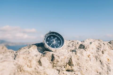 Close up compass on a mountain top. Stock Photos