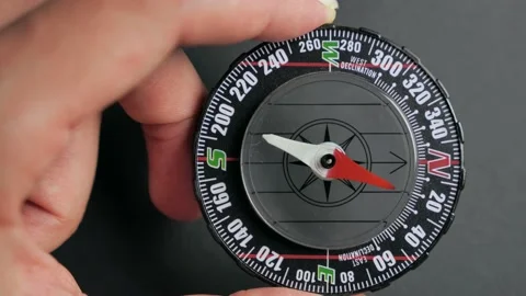 Close up compass with moving needle on top on black background Stock Footage 138401817
