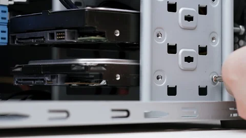 Close-up computer assembly. A man installs hard drives in the computer case Stock Footage 105422569