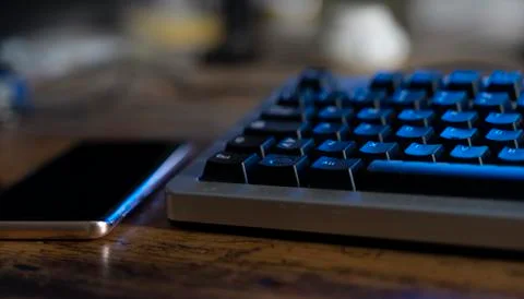 Close-up of computer keyboard and smartphone on a wooden table Stock Photos
