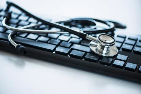 Close up of computer keyboard and stethoscope, studio shot Stock Photos