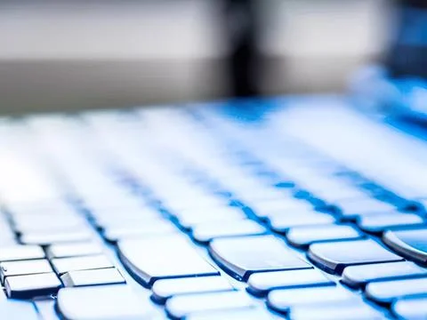 Close-up of a computer keyboard with blue backlight Stock Photos