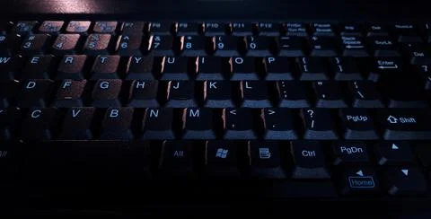 Close-up of computer keyboard in dark background. Stock Photos