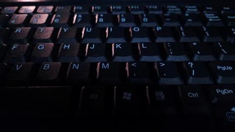 Close-up of computer keyboard in dark background. Stock Photos