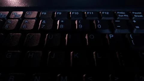 Close-up of computer keyboard in dark background. Stock Photos