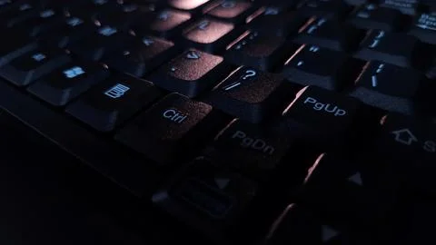 Close-up of computer keyboard in dark background. Stock Photos