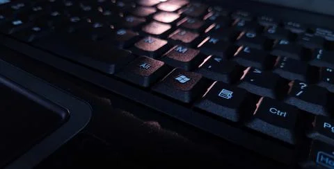 Close-up of computer keyboard in dark background. Stock Photos