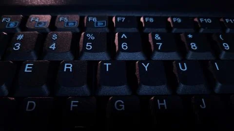 Close-up of computer keyboard in dark background. Stock Photos