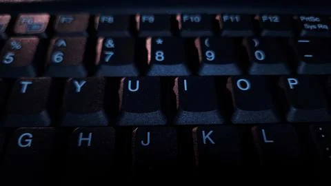 Close-up of computer keyboard in dark background. Stock Photos