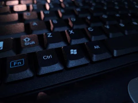 Close-up of computer keyboard in dark background. Stock Photos