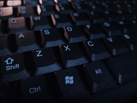Close-up of computer keyboard in dark background. Stock Photos