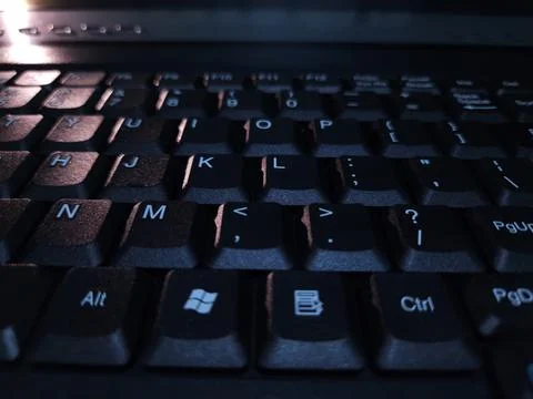 Close-up of computer keyboard in dark background. Stock Photos