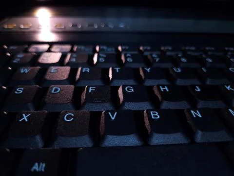 Close-up of computer keyboard in dark background. Stock Photos