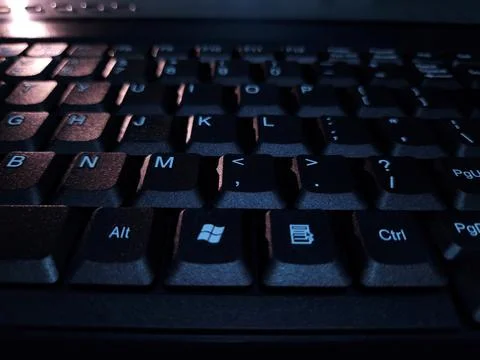 Close-up of computer keyboard in dark background. Stock Photos