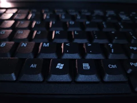 Close-up of computer keyboard in dark background. Stock Photos