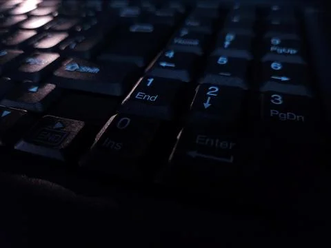 Close-up of computer keyboard in dark background. Stock Photos