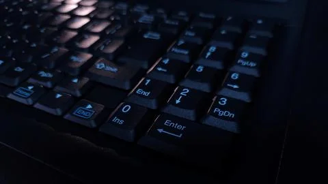 Close-up of computer keyboard in dark background. Stock Photos