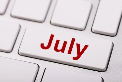 Close-up of a computer keyboard with a red "July" key, symbolizing time man.. Stock Photos
