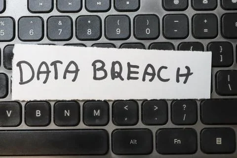 Close-up of a computer keyboard showcasing a note that reads DATA BREACH. The Stock Photos