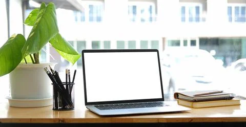 Close up computer laptop with white screen on wood table in modern office.. Stock-Fotos