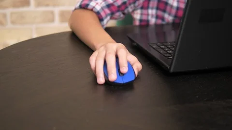 Close-up. Computer mouse in the hand of a teenage boy using a laptop. Video stock 113577146