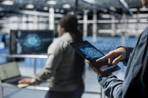 Close up of computer scientist in server hub using tablet to enhance AI models Stock Photos