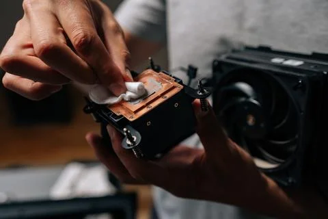 Close-up of computer technician cleaning processor cooling system with soft 写真素材